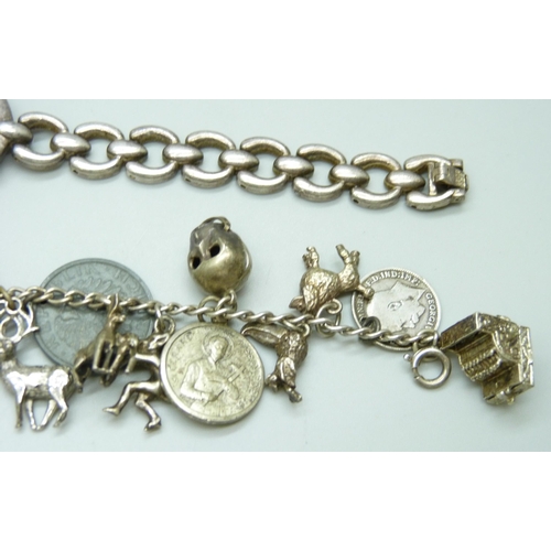 7133 - A white metal charm bracelet with a collection of silver and white metal charms, a silver napkin rin... 