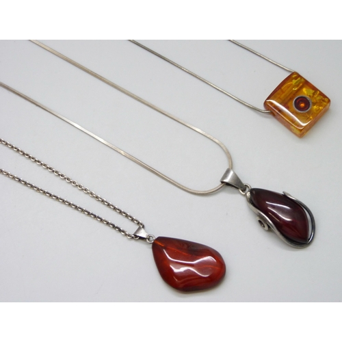 7135 - Three silver and amber pendants and chains, 32g