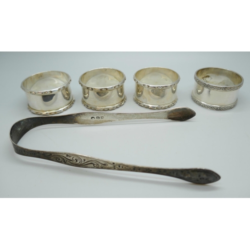 7246 - A set of four silver napkin rings and silver sugar nips, 133g