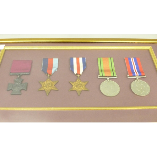 2005 - A group of four mounted World War II medals with a replica Victoria Cross, with commemorative inscri... 