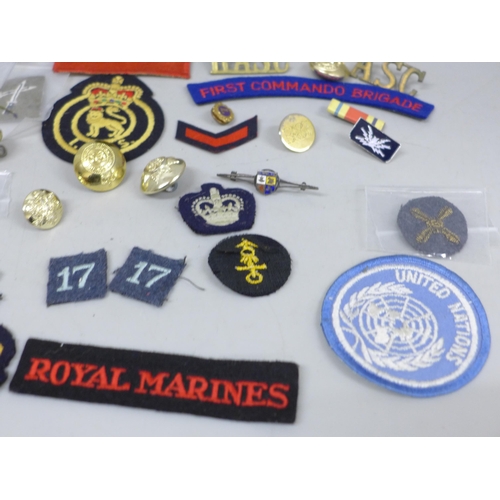 2020 - A collection of military uniform patches, cap badges and buttons