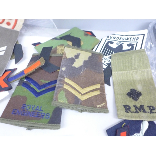 2034 - A collection of militaria epaulettes, badges, insignia, etc.