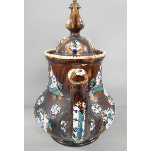 2257 - A large 19th Century salt-glazed Measham bargeware teapot with relief floral and bird motif, and tea... 