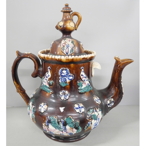 2257 - A large 19th Century salt-glazed Measham bargeware teapot with relief floral and bird motif, and tea... 