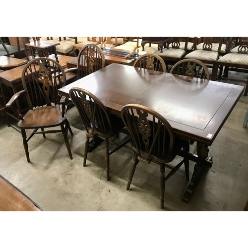 248 - An oak draw leaf dining table and a set of six beech wheelback dining chairs