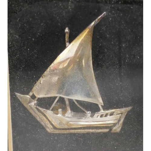 7343 - A framed white metal model of a ship, and a framed Arabic dagger, largest frame 37cm