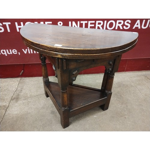 184 - A 17th Century style oak demi lune fold over tea table