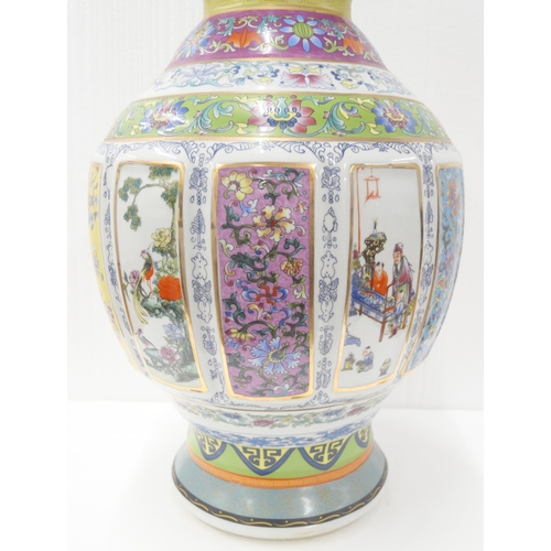 2180 - A large Chinese famille rose temple vase with panelled oriental scenes and gilt twin handles. With s... 