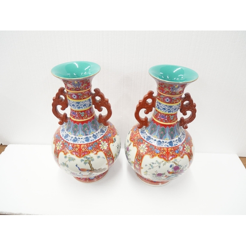 2181 - A pair of Chinese Qianlong vases with red famille rose design and motif scenes of birds. With stamp ... 