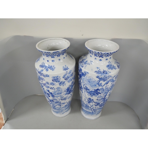 2185 - A pair of large late 19th Century oriental blue and white vases. Each with floral bird design. Measu... 