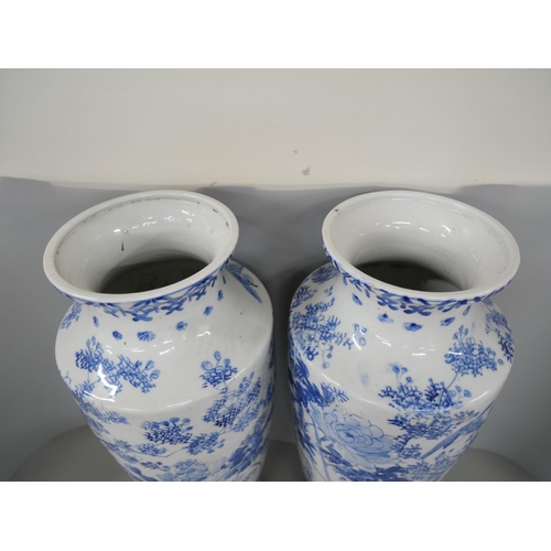 2185 - A pair of large late 19th Century oriental blue and white vases. Each with floral bird design. Measu... 