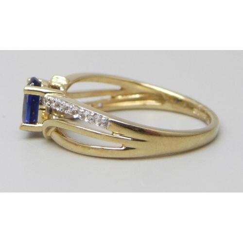 7011 - A 9ct gold ring set with a central blue stone and white stone shoulders, 2g, J