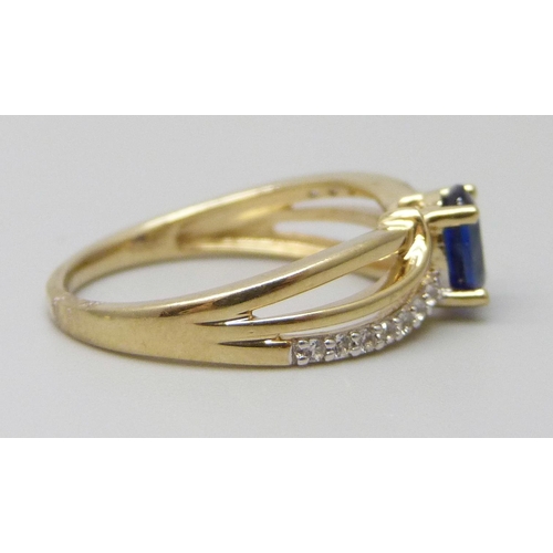 7011 - A 9ct gold ring set with a central blue stone and white stone shoulders, 2g, J