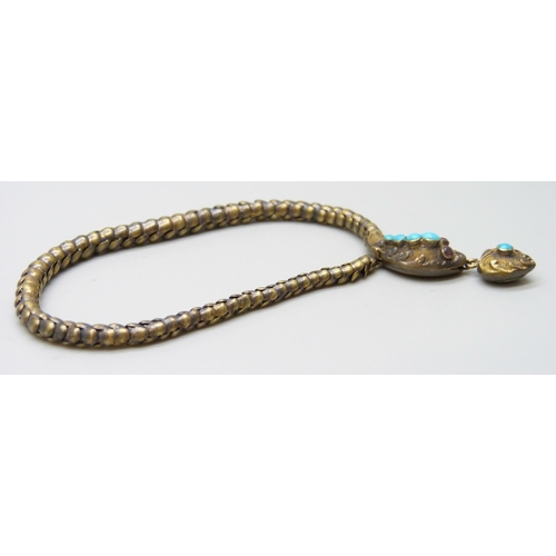 7021 - A Victorian gilt snake bracelet, the serpent's head set with turquoise and garnet eyes, and the hear... 