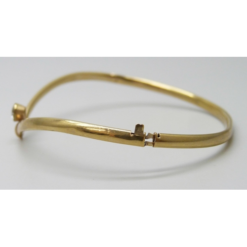 7023 - A 9ct gold bangle set with a white paste stone, 3.1g, a/f