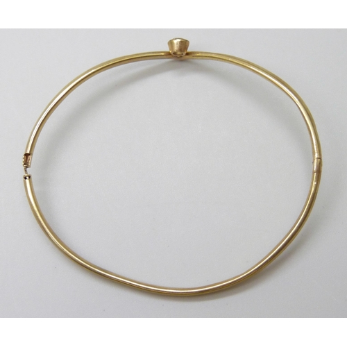 7023 - A 9ct gold bangle set with a white paste stone, 3.1g, a/f