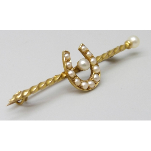 7025 - A yellow metal bar brooch set with seed pearls and horseshoe motif, 2.5g, 4.5cm