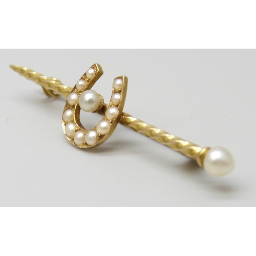 7025 - A yellow metal bar brooch set with seed pearls and horseshoe motif, 2.5g, 4.5cm