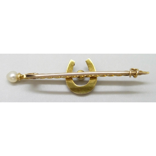 7025 - A yellow metal bar brooch set with seed pearls and horseshoe motif, 2.5g, 4.5cm