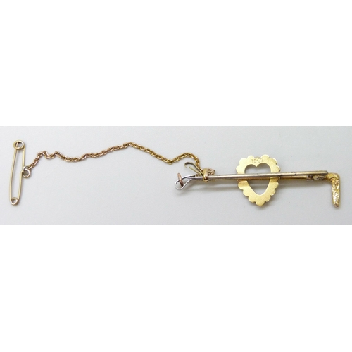 7057 - A 15ct gold and seed pearl brooch in the form of a riding crop, yellow metal safety chain, metal pin... 