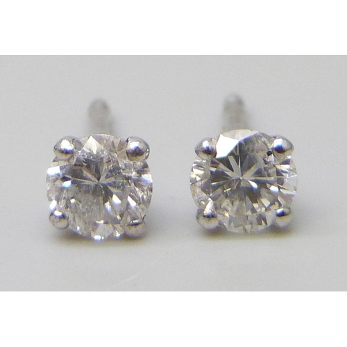 7064 - A pair of 18ct white gold and diamond stud earrings, each approximately 0.25 carat