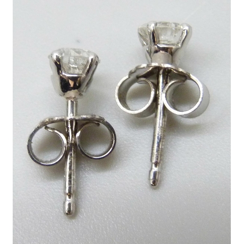 7064 - A pair of 18ct white gold and diamond stud earrings, each approximately 0.25 carat