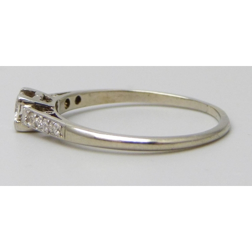 7067 - A white metal diamond set ring, approximately 0.2 carat main stone, indecipherable marks, 1.7g, P/Q