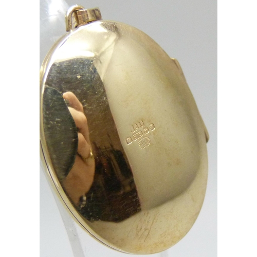 7076 - A 9ct gold oval locket with engraved design, 4.4g, 3.5cm including bale