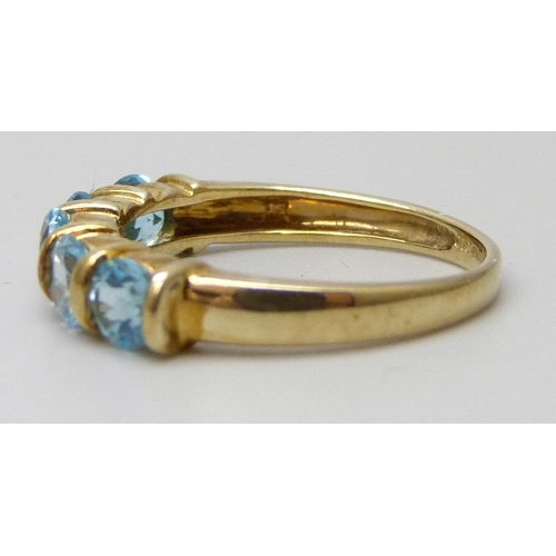 7095 - A 9ct gold ring set with five blue stones, 2g, N