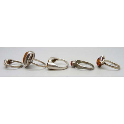 7114 - Five silver and amber rings, one .830 silver, 14.8g