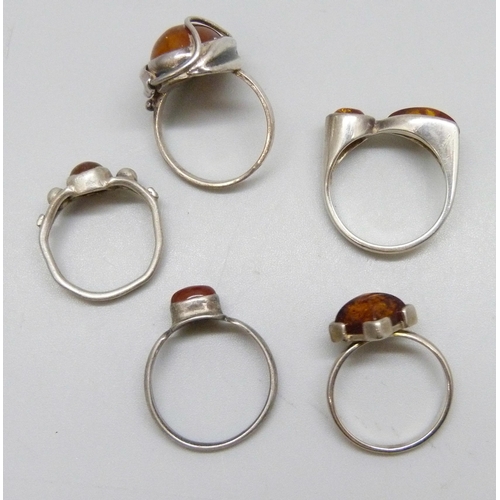 7114 - Five silver and amber rings, one .830 silver, 14.8g