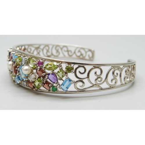 7124 - A silver multi-coloured gemstone cuff bangle, 15g, 1.5cm wide in centre