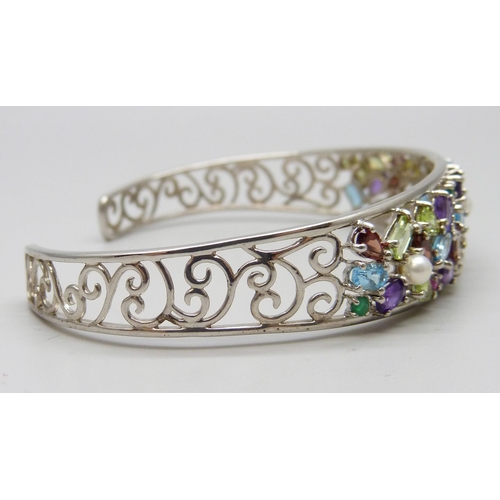 7124 - A silver multi-coloured gemstone cuff bangle, 15g, 1.5cm wide in centre