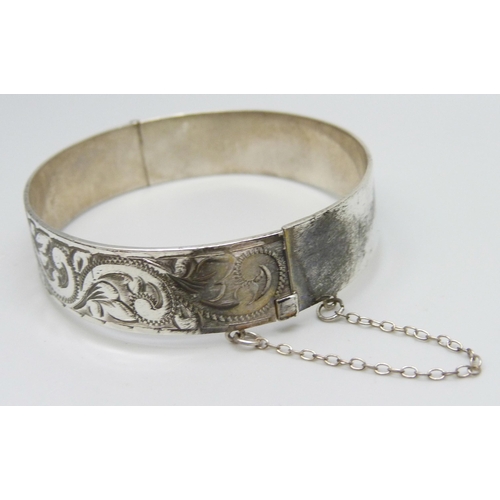 7148 - A silver bangle with engraved decoration, 23g, 5.9 x 5.2cm