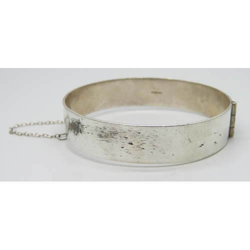 7148 - A silver bangle with engraved decoration, 23g, 5.9 x 5.2cm