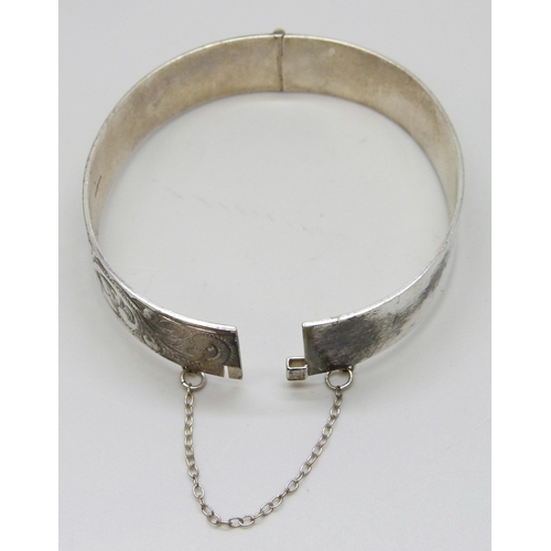 7148 - A silver bangle with engraved decoration, 23g, 5.9 x 5.2cm