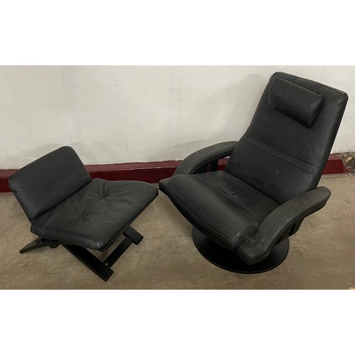 63 - A Swedish black vinyl lounge chair and footstool