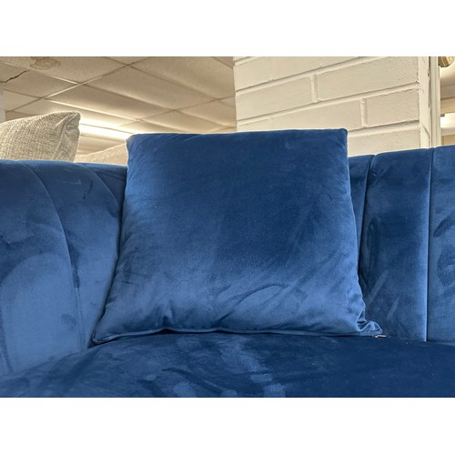 3106 - A blue velvet four seater sofa