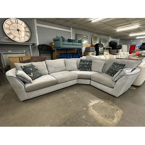 3206 - A stone grey upholstered three piece corner sofa with blue piping