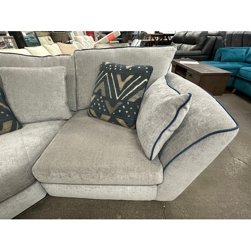 3206 - A stone grey upholstered three piece corner sofa with blue piping