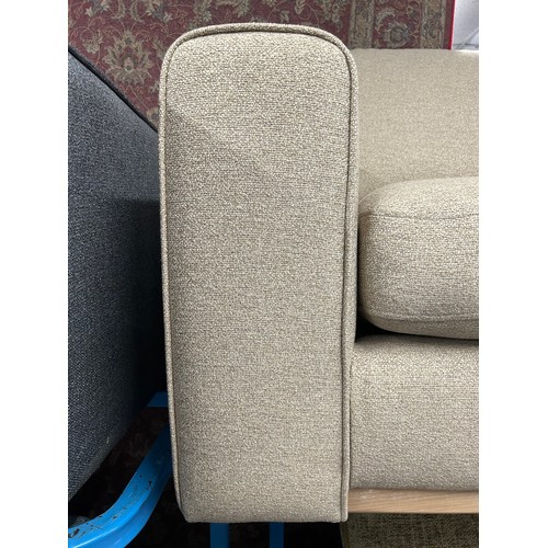 3249 - A beige upholstered three seater sofa with exposed wood