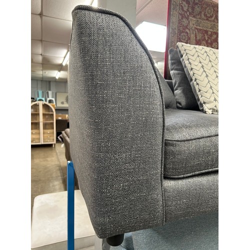 3216 - A dark grey upholstered three seater sofa