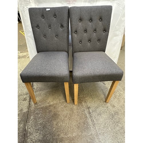 3302 - A pair of grey buttoned dining chairs with wooden legs *This lot is subject to VAT