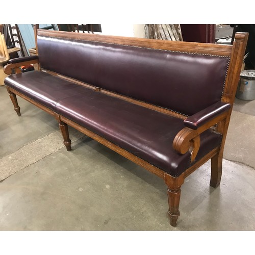 109 - An early 20th Century oak and red leather upholstered settle