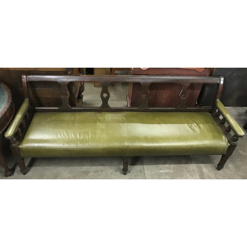 110 - A Victorian oak and green leather upholstered settee