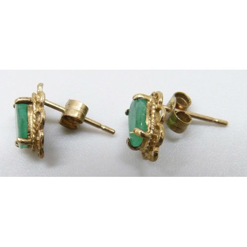 7013 - A pair of yellow metal emerald set stud earrings, the butterflies marked 9c, 0.9g, 8mm