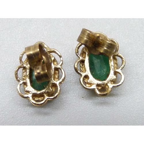 7013 - A pair of yellow metal emerald set stud earrings, the butterflies marked 9c, 0.9g, 8mm