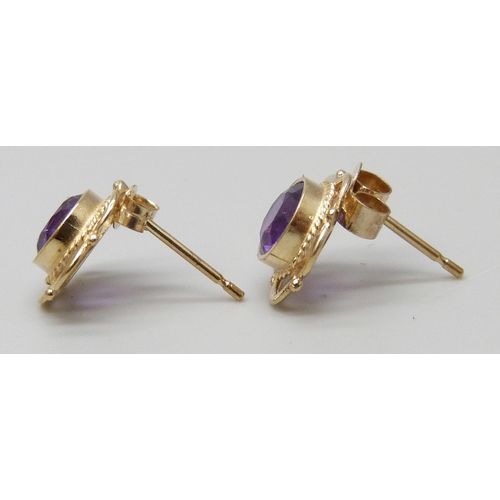 7039 - A pair of yellow metal amethyst stud earrings, unmatched butterflies, 1.1g