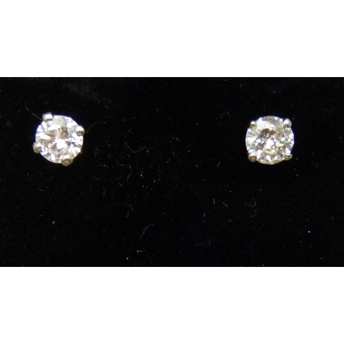 7055 - A pair of hallmarked 18ct white gold diamond stud earrings, total diamond weight 0.50ct