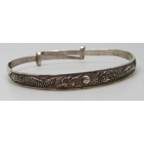 7093 - A white metal dragon design bangle with Oriental marks, 13g, a/f